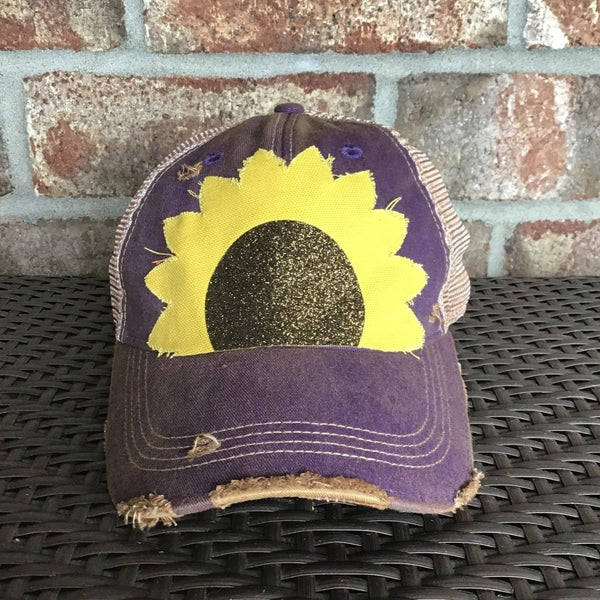 Sunflower hat by BohoGroove with yellow sunflower petals and a black glitter sunflower center on a purple vintage distressed snapback.