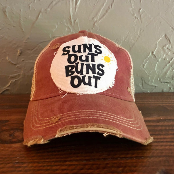 Suns Out Buns Out hat by BohoGroove with black lettering and yellow sun graphic on distressed off-white patch on brick red vintage distressed snapback.