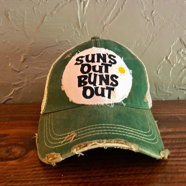 Suns Out Buns Out hat by BohoGroove with black lettering and yellow sun graphic on distressed off-white patch on green vintage distressed snapback.