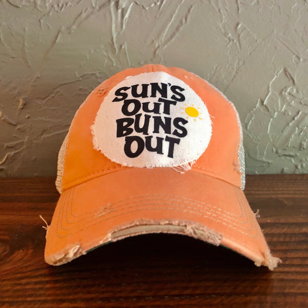 Suns Out Buns Out hat by BohoGroove with black lettering and yellow sun graphic on distressed off-white patch on sherbet vintage distressed snapback.