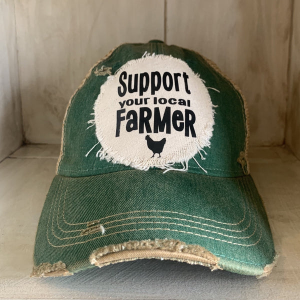 Support Your Local Farmer hat by BohoGroove with black Support Your Local Farmer lettering and chicken graphic on a distressed off-white patch on a green vintage distressed snapback.