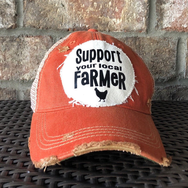 Support Your Local Farmer hat by BohoGroove with black Support Your Local Farmer lettering and chicken graphic on a distressed off-white patch on an orange vintage distressed snapback.