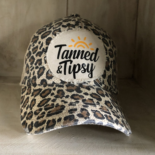 Tanned and Tipsy Hat by BohoGroove on a distressed leopard snapback trucker hat with hand-applied patch design and vintage weathered style.