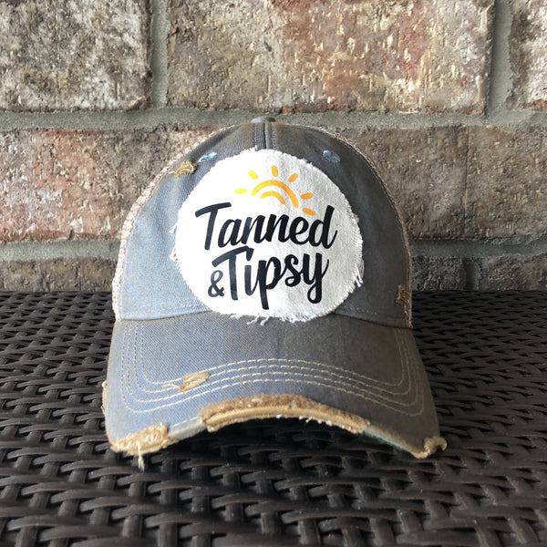 Tanned and Tipsy Hat by BohoGroove on a distressed light blue snapback trucker hat with hand-applied patch design and vintage weathered style.