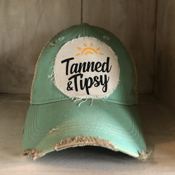 Tanned and Tipsy Hat by BohoGroove on a distressed mint snapback trucker hat with hand-applied patch design and vintage weathered style.