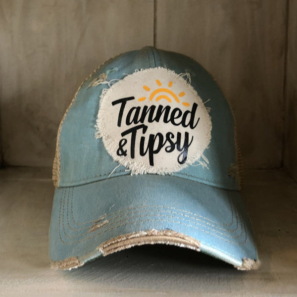 Tanned and Tipsy Hat by BohoGroove on a distressed ocean blue snapback trucker hat with hand-applied patch design and vintage weathered style.