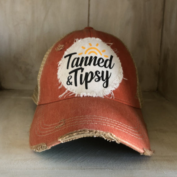 Tanned and Tipsy Hat by BohoGroove on a distressed orange snapback trucker hat with hand-applied patch design and vintage weathered style.
