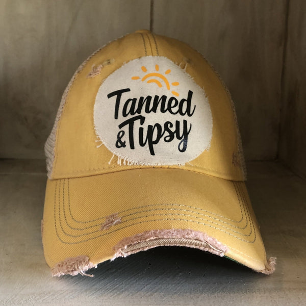Tanned and Tipsy Hat by BohoGroove on a distressed yellow snapback trucker hat with hand-applied patch design and vintage weathered style.