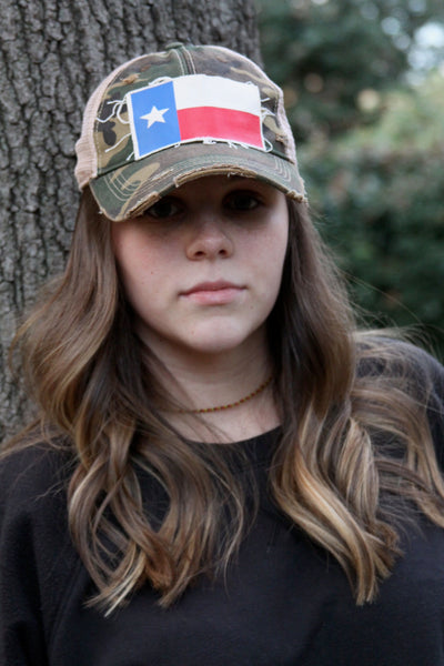 Lifestyle photo of BohoGroove Texas flag hat featuring a Texas flag patch on camo vintage distressed snapback