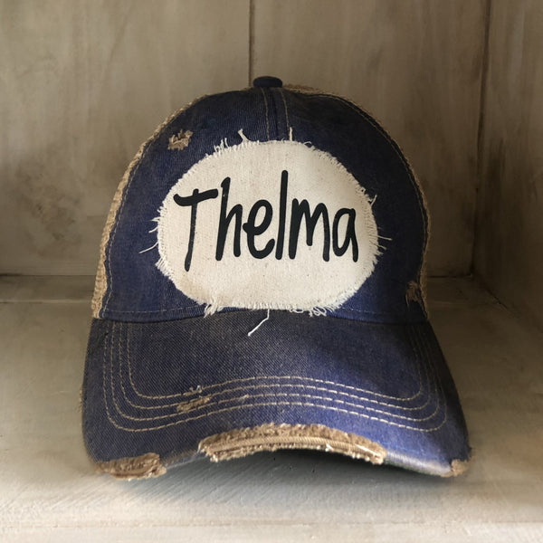 Thelma hat by BohoGroove with black Thelma lettering on a distressed off-white patch on a royal blue vintage distressed snapback trucker hat.