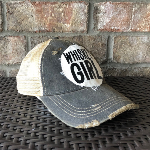 Left side view of Whiskey Girl hat by BohoGroove with black lettering on a distressed off-white patch on a black vintage distressed snapback.