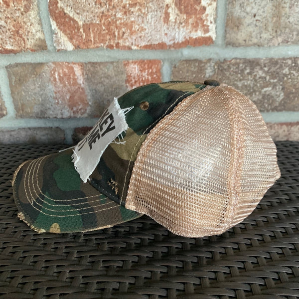 Right side view of a camo vintage distressed snapback trucker hat by BohoGroove featuring a distressed off-white patch with black Whiskey Made Me Do It lettering.