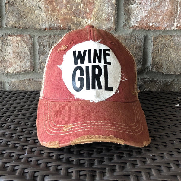 Wine Girl hat by BohoGroove with black Wine Girl lettering and wine glass graphic on a distressed off-white patch on a brick red vintage distressed snapback trucker hat.