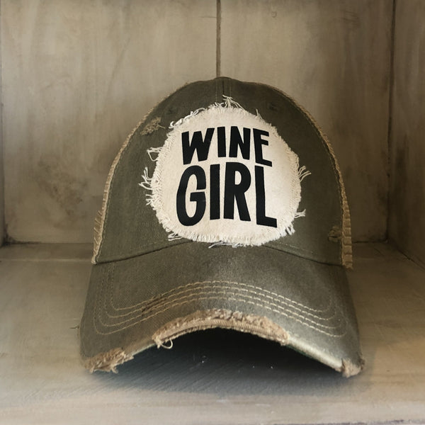 Wine Girl hat by BohoGroove with black Wine Girl lettering and wine glass graphic on a distressed off-white patch on an olive vintage distressed snapback trucker hat.