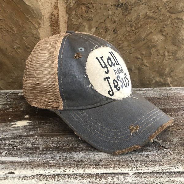 Y’all Need Jesus Hat by BohoGroove with black Y’all Need Jesus lettering on distressed off-white patch on a light blue vintage distressed snapback left side